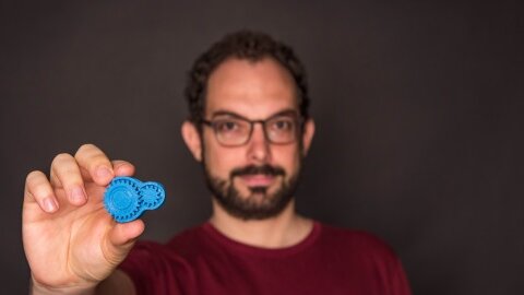 Lukas Abegg tient dans sa main un objet issu d'une imprimante 3D