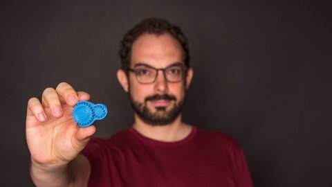 Lukas Abegg che tiene in mano un oggetto proveniente da una stampante 3D
