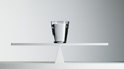 Bicchiere d'acqua su bilancia bilanciata